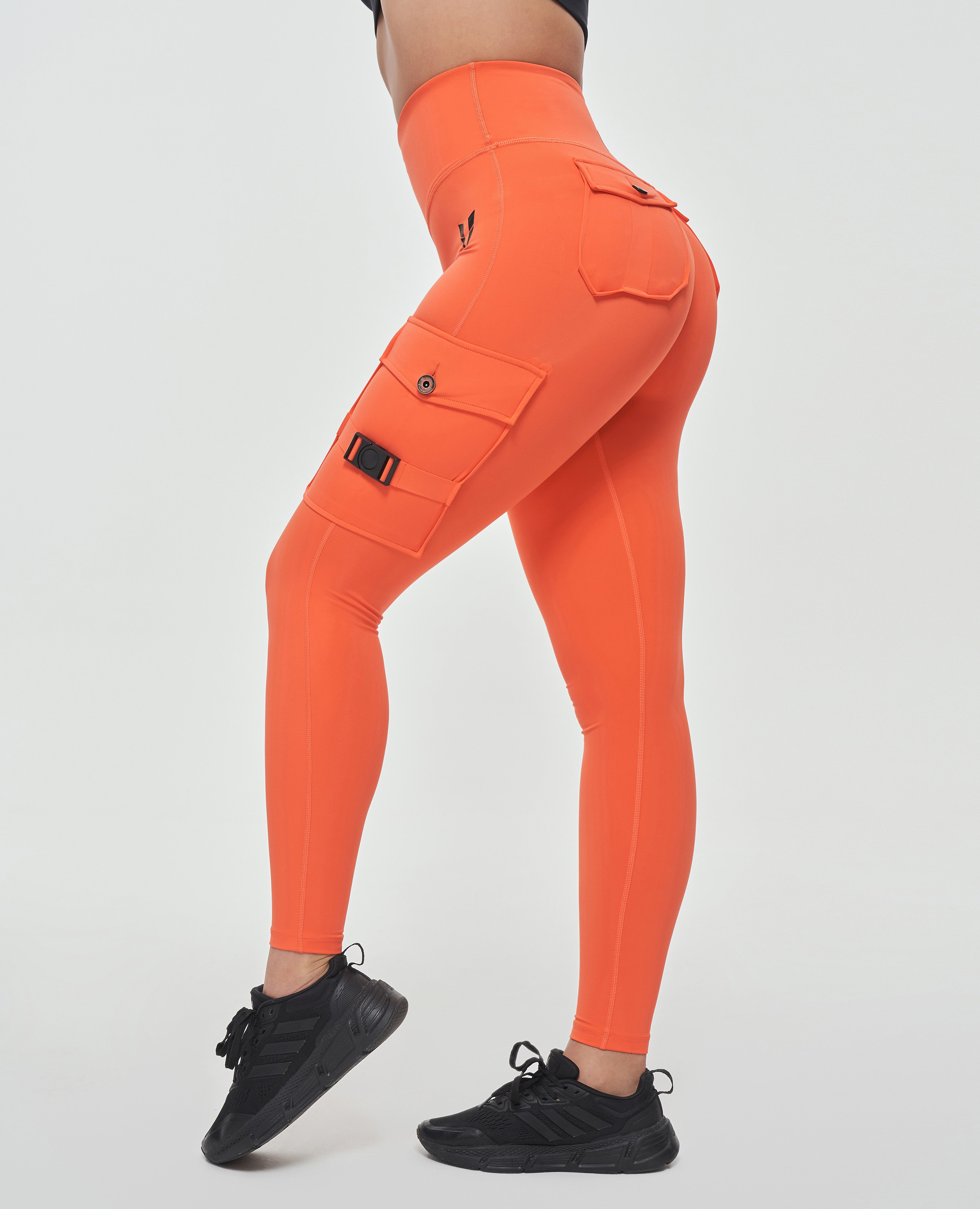FIRM ABS orange durable leggings for outdoor activities with side pockets worn with black sneakers