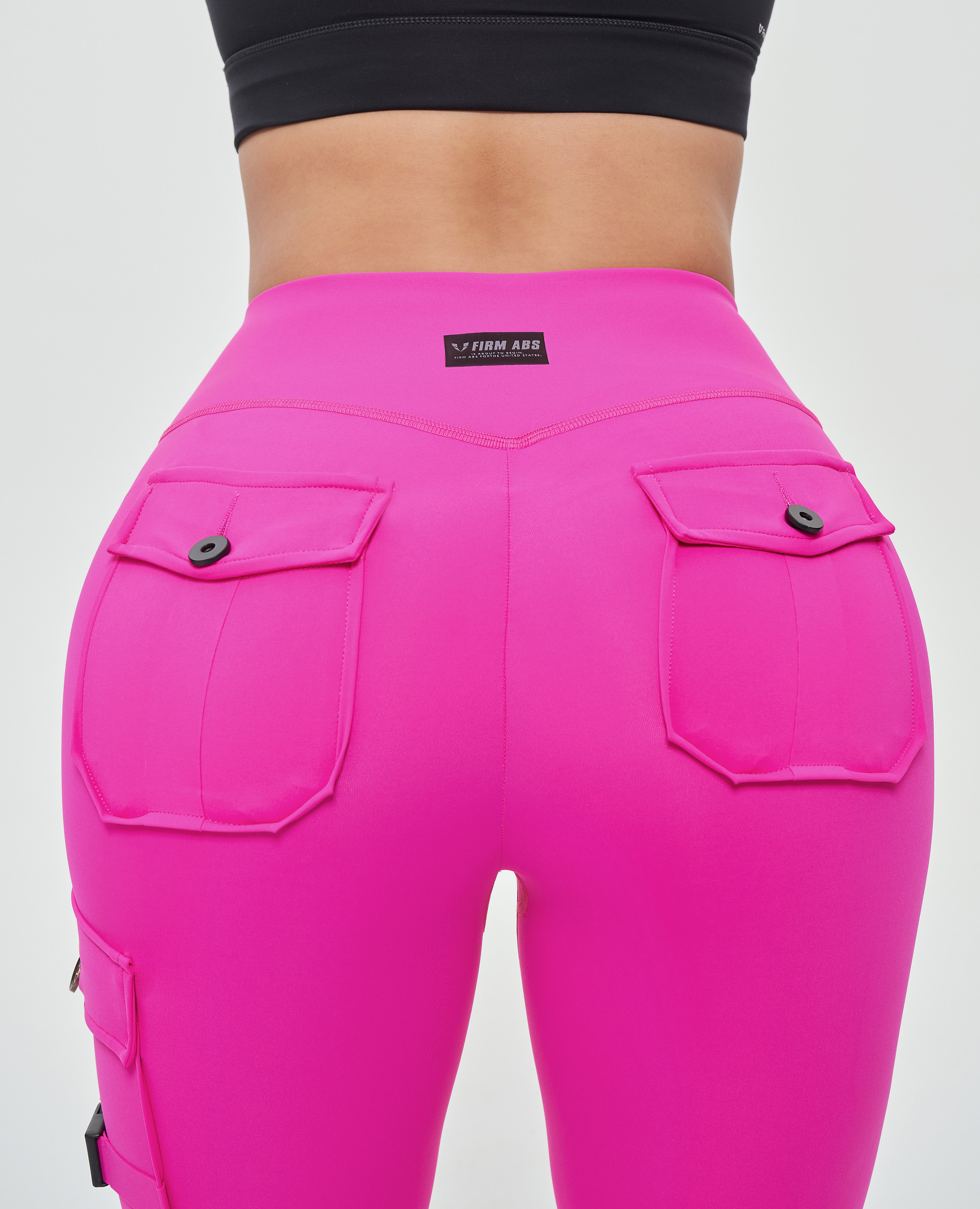 FIRM ABS women's fitness leggings with pockets in bright pink featuring buttoned back pockets