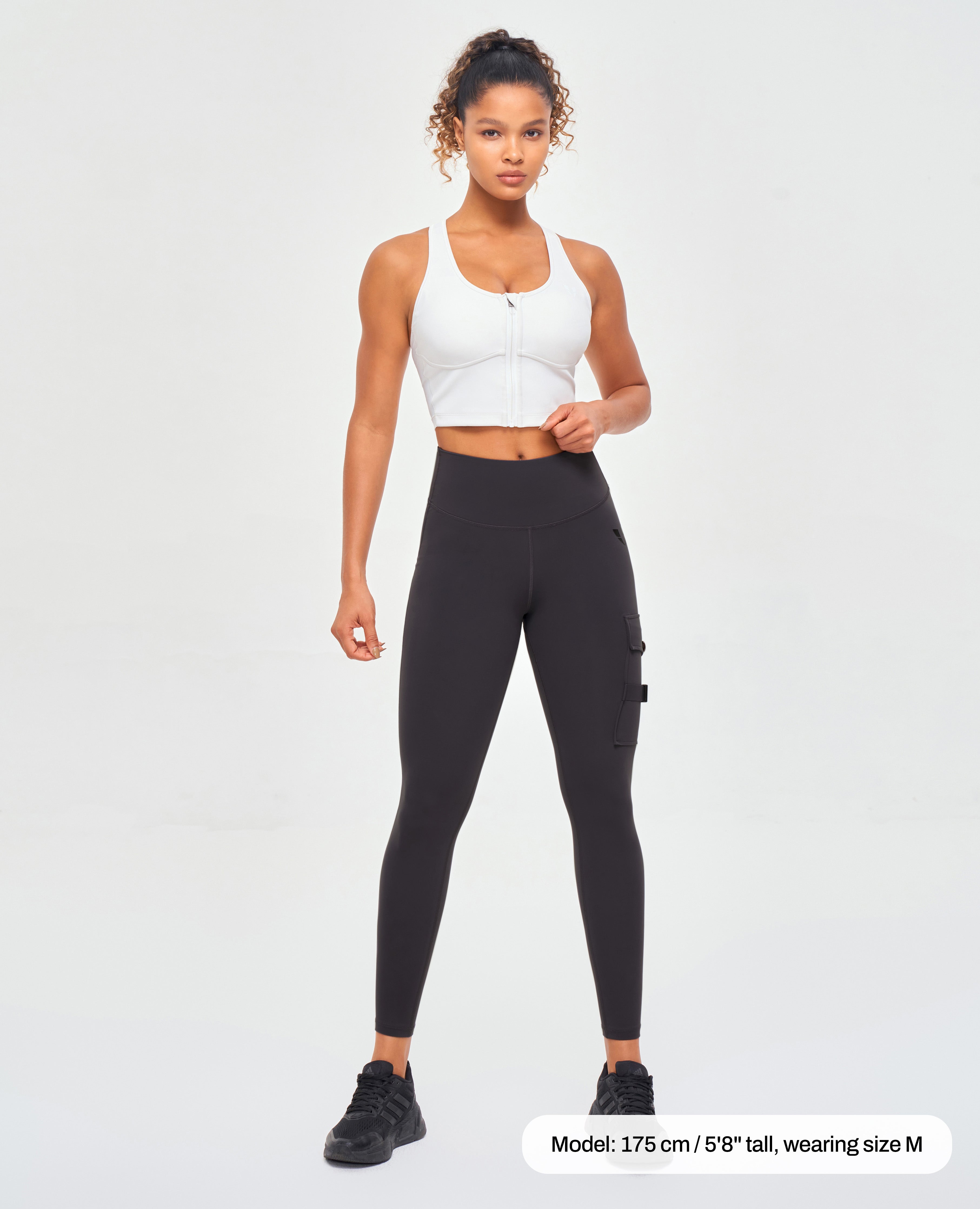 FIRM ABS women's fitness leggings with pockets in black worn by model with white crop top
