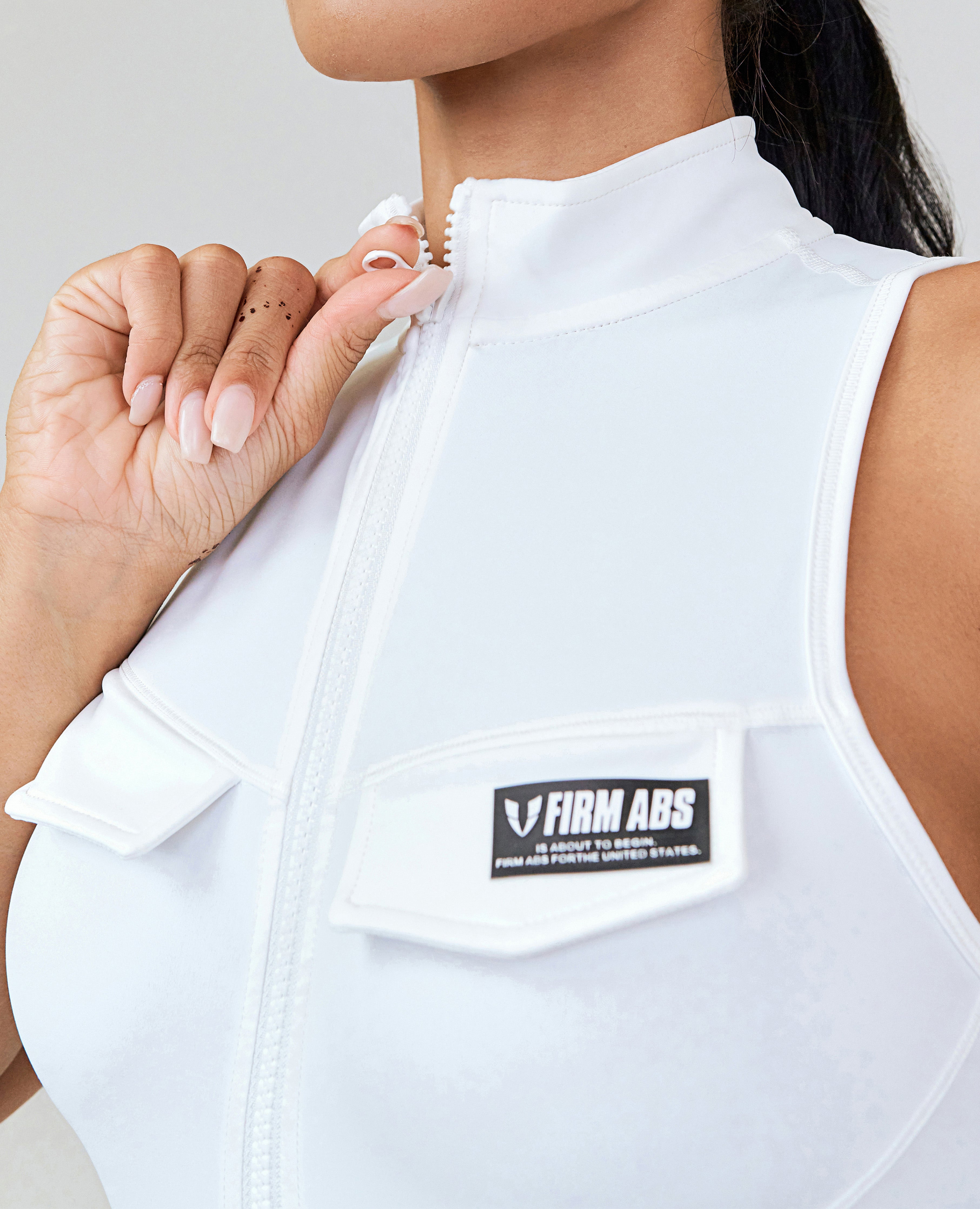 FIRM ABS white zip front sports tank with high collar and chest pocket detail