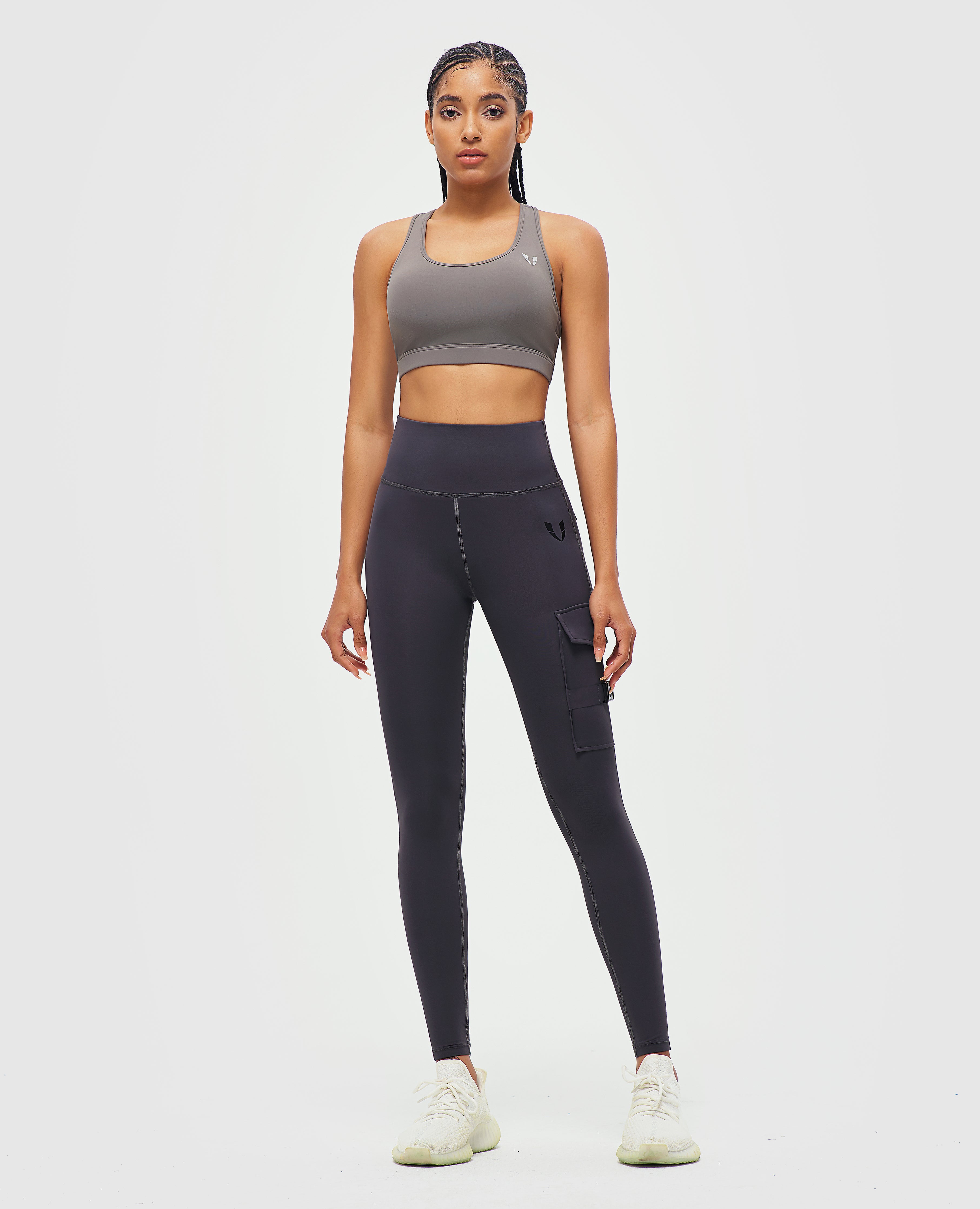 FIRM ABS women's fitness leggings with pockets in black modeled with gray sports bra and white sneakers